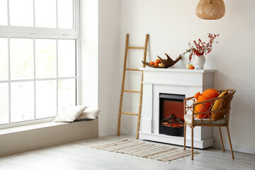 Interior of light room with modern fireplace, armchair and ladder