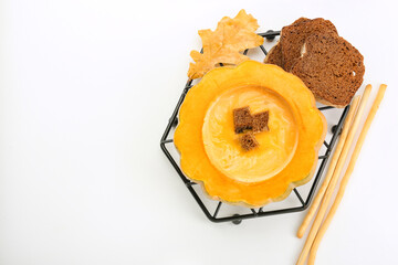 Tasty soup served in pumpkin with bread on white background