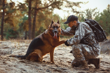 Military working dog giving paw to soldier outdoors