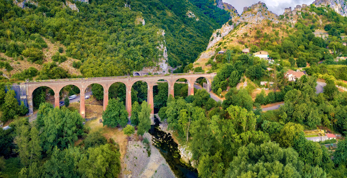 Fresh green view from flying drone of ancient bridge across the Devil's Throat Gorge, San Severino village location. Picturesque summer scene of Mingardo river, Italy. Traveling concept background.