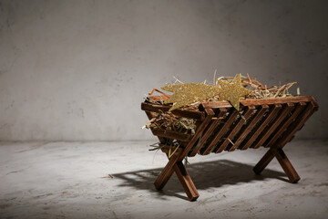 Manger with hay on light background