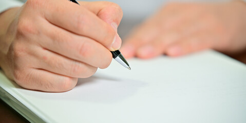 Business man's hand holding white paper and pen with copy space