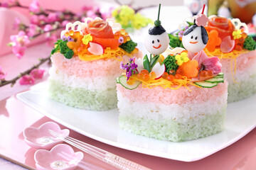 Obraz na płótnie Canvas Home made diamond-shaped sushi cake for japanese dool's festival. Tiny dolles made from quail eggs , ham, boild vegetable and edible flowers. か わいいひな祭り　おひな様ケーキ　ちらしケーキ寿司　ひし形ケーキ　