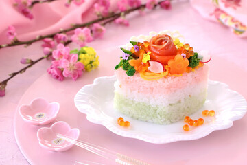 Obraz na płótnie Canvas Home made diamond-shaped sushi cake for japanese dool's festival. Beautiful flower shaped sushi. かわいいひな祭り　お花ケーキ　ちらしケーキ寿司　ひし形ケーキ　