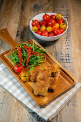Calf escutcheon recipe for Milanese, Parmesan, Roquette and candied tomatoes