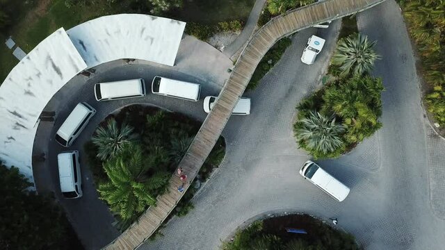 Top View Of White Shuttle Vans At The Entrance Of Resort. - aerial