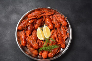 Red boiled crawfishes on table in rustic style. Asian Chinese Food Spicy Crayfish on an iron plate with a mug of beer.