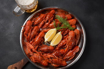 Red boiled crawfishes on table in rustic style. Asian Chinese Food Spicy Crayfish on an iron plate with a mug of beer.