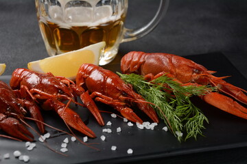 Red boiled crawfishes on table in rustic style. Asian Chinese Food Spicy Crayfish with a mug of beer.