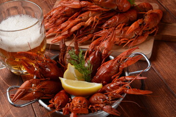 Red boiled crawfishes on table in rustic style. Asian Chinese Food Spicy Crayfish with a mug of beer.