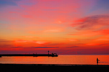 Crimson lights covering the sky and the sea in early morning before sunrise at Hua Hin beach, Thailand 3