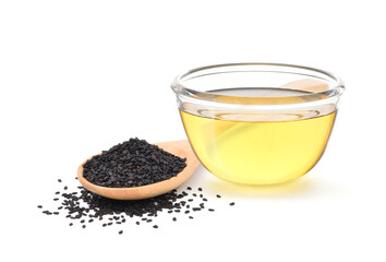 Sesame oil in glass bowl with black sesame seed in wooden spoon isolated on white background.