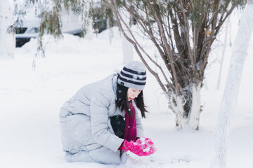 Fototapeta na wymiar Oriental girls playing in the snow in winter