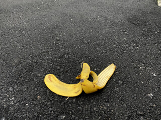 View of a banana peel on the asphalt road waiting for someone to slip on (asphalt texture is not...