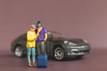 Miniature people Couple looking at their smartphones for planning a trip. Travel and Adventure concepts