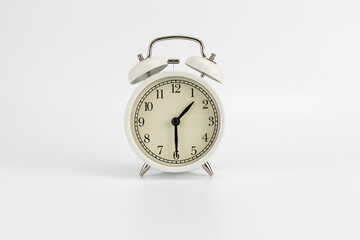White retro clock alarm clock on white background shows 01:30 am or 01:30 pm or 13:30