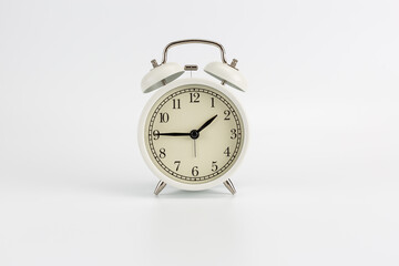 White retro clock alarm clock on white background shows 01:45 am or 01:45 pm or 13:45