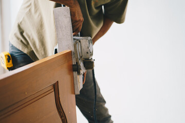 Carpenter working on wood craft at workshop to produce interior house construction material