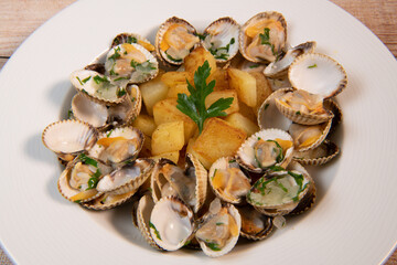 Steamed cockles with fried potatoes in the white dish, mariniere recipe