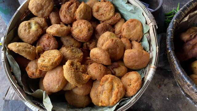 Various fast foods like Piiyaji, gulgula, bara, aloo chop, mangso chop, etc, are being sold by cart puller called thelawalla , are displayed for sale. Image of street foods of Kolkata, West Bengal.