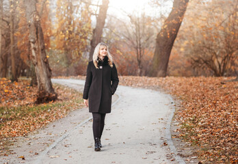 Autumn woman in autumn park. Warm sunny weather. Fall concept