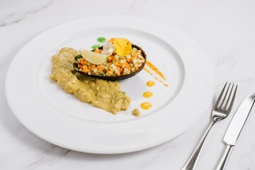 Dish with avocado and chopped wegetables with sauce. Detox menu