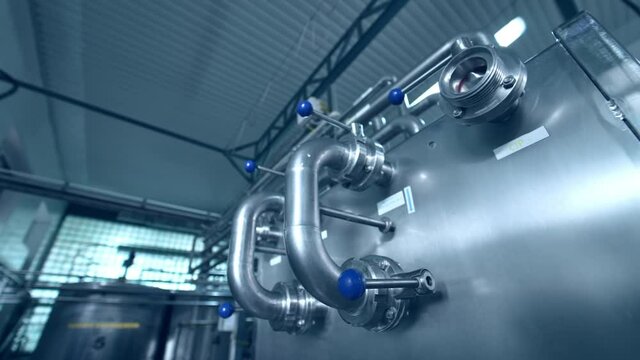 Dairy factory with milk pasteurization tank and pipes. Motion camera view