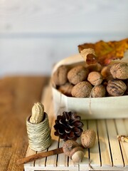 On the oak table there are wooden pallets with walnuts and hazelnuts on them