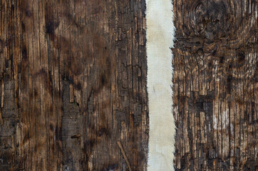 A thin strip of coarse cloth on a textured wooden surface