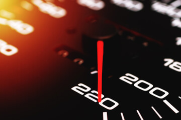 Car speedometer. Auto car speedometer shows 220 km h or miles.Closeup shot,dark black background.Automobile dangerous speed concept