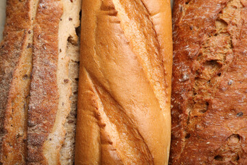 Different tasty baguettes as background, top view