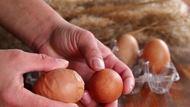 Close-up view of a deformed chicken egg. An ugly abnormal crooked egg compared to the right one. Lack of trace elements in the body of old chickens