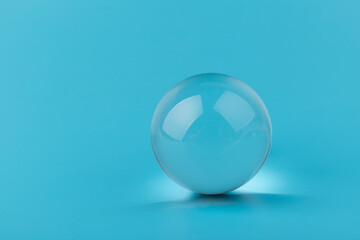 Crystal glass ball sphere transparent on blue background.