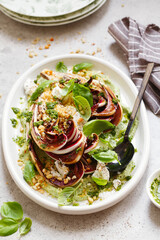 roasted radicchio salad with feta, green tahini, Pine nuts and basil pesto. Radicchio rosso di treviso tardivo, italian red chicory. Healthy Meal recipe preparation. Plant-based dishes.