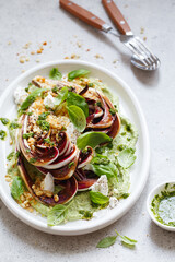 roasted radicchio salad with feta, green tahini, Pine nuts and basil pesto. Radicchio rosso di treviso tardivo, italian red chicory. Healthy Meal recipe preparation. Plant-based dishes.