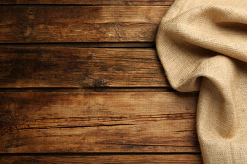 Natural burlap fabric on wooden table, top view. Space for text