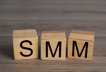 Cubes with abbreviation SMM (Social media marketing) on wooden table
