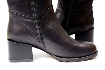 Black leather women’s boots fastened with a zipper. Background for shoes.