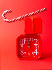 Toy, red watch, gift, lollipop, candy on a red background.