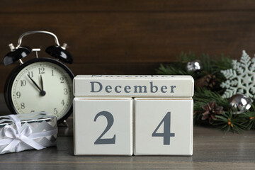 December 24 - Christmas Eve. Wooden block calendar and festive decor on table