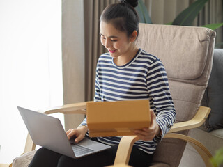 Business woman checking her orders on laptop computer. e-commerce concept.
