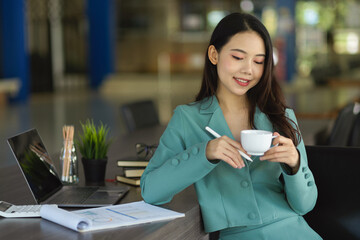 Business woman sitting in board room and sipping hot tea.