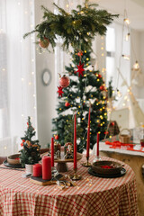 Beautiful table setting for Christmas dinner. Spruce branches with red christmas ornament