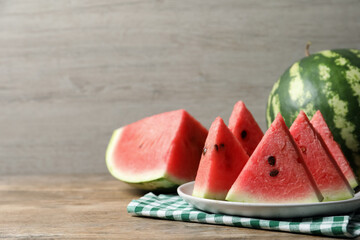 Delicious fresh watermelon slices on wooden table. Space for text