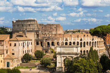 Fototapeta na wymiar View of the Roman Forum with buildings, Arch of Titus and the Colosseum. Rome, Italy
