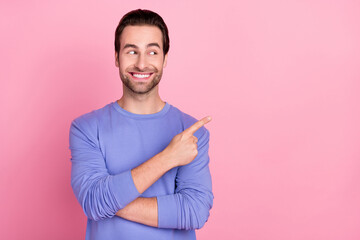 Photo of brunet cunning guy indicate look empty space wear blue pullover isolated on pink color...