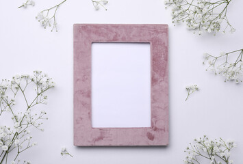 Frame and beautiful gypsophila flowers on white background, flat lay. Space for text