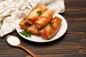 Portion of stuffed cabbage rolls on wooden table