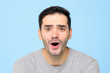 Surprised handsome Caucasian man gasping in isolated light blue studio background