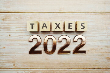 Taxes 2022 alphabet letter on wooden background